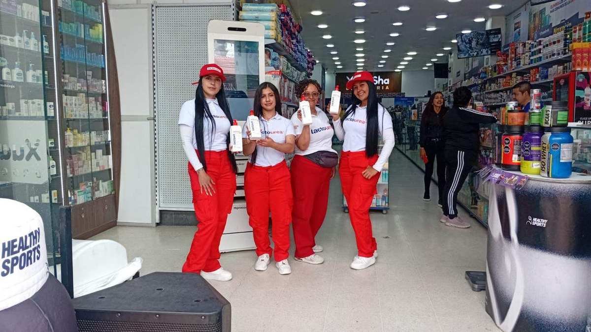 Promotoras de AgenciaBTL con uniforme de marca y producto de cuidado de la piel en una droguería